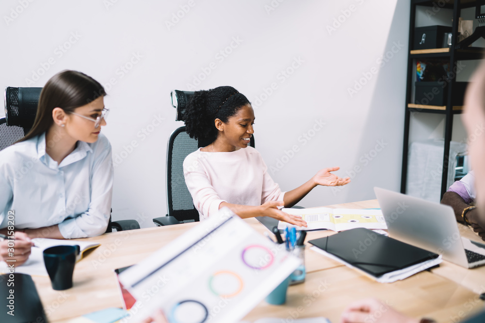 Fototapeta premium Professional proud ceo discussing business strategy of developing project during working time in office room, diverse colleagues in formal wear collaborating and getting great experience togetherness