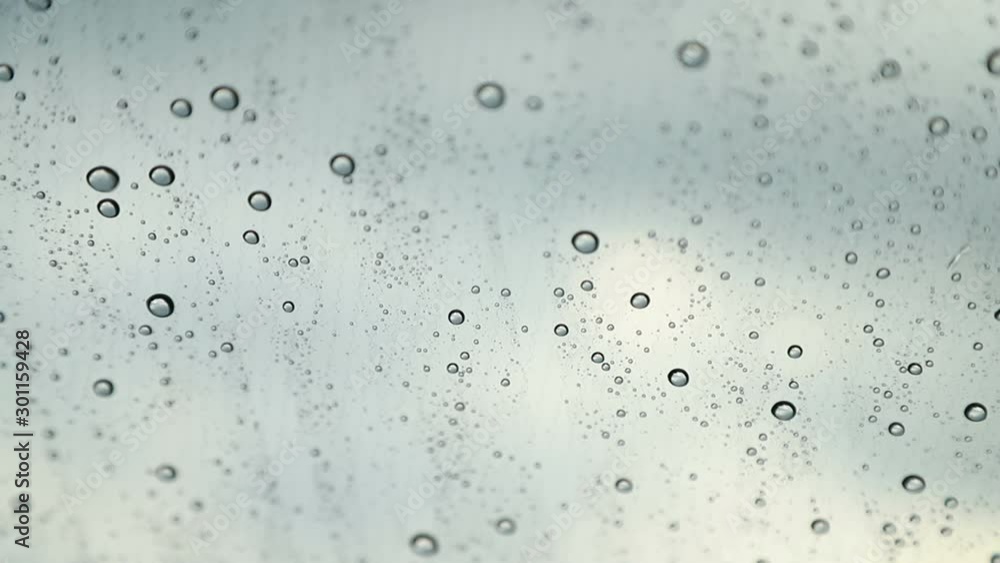 Raindrops drip on the windshield of the car close-up. Nano-coating of the windscreen Raindrops drip on the windshield of the car close-up. Nano-coating of the windscreen