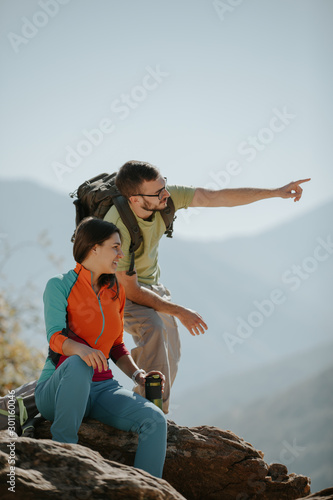 Couple hikers taking a break on the mountaintop © Suteren Studio