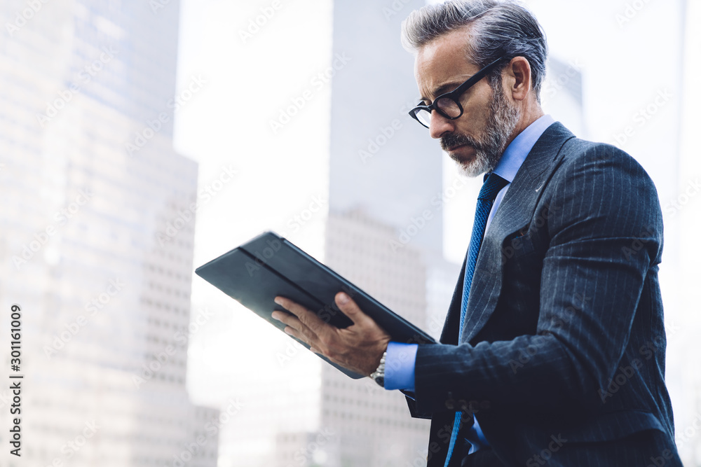 Middle aged businessman using tablet on New York street Middle aged businessman using tablet on New York street