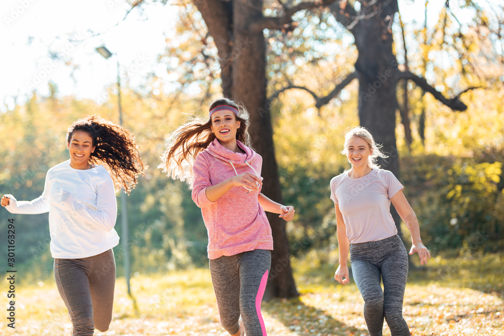 Fototapeta premium Group of female friends jogging at the city park in the morning.Autumn season