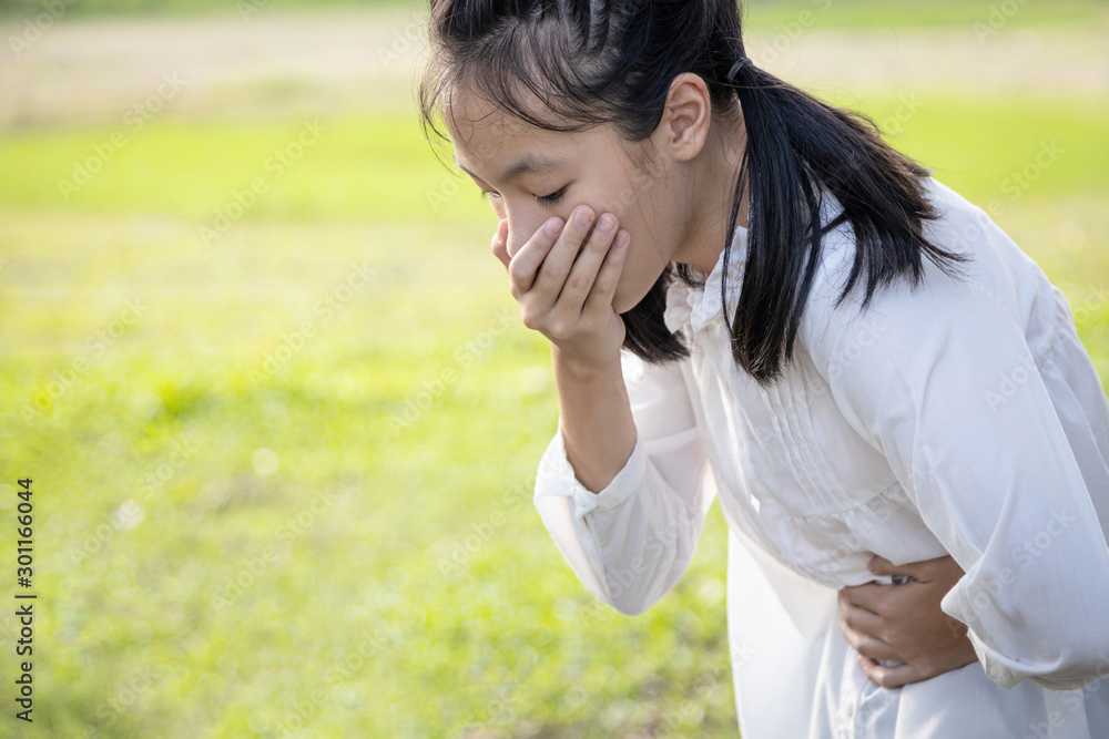 Asian beautiful child girl covered her mouth about to throw up,vomit
