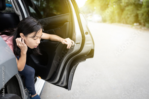 Obraz na plátne Unhappy asian child girl about to throw up from car sick or indigestion,female t