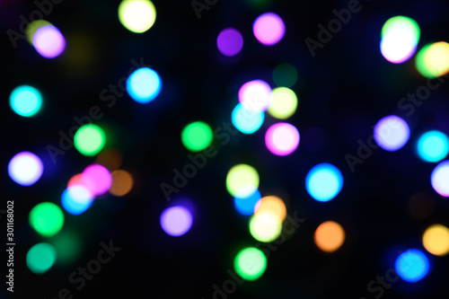 blurred night multicolored glowing lights on black background. new year and christmas concept