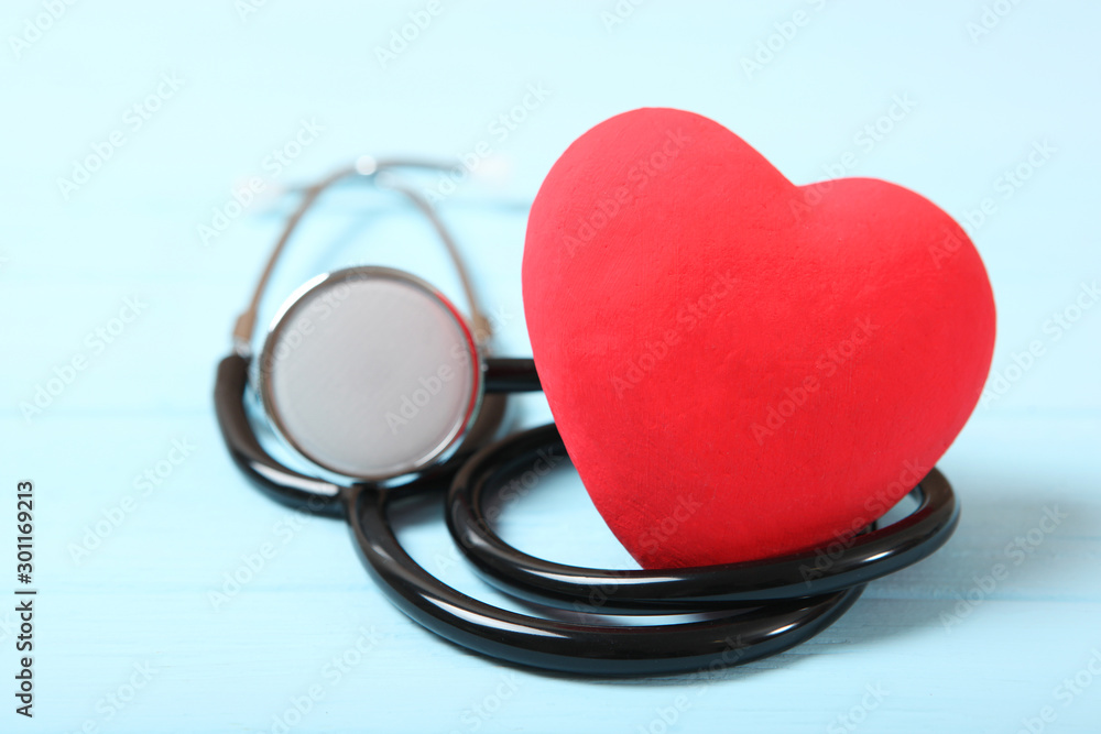 Stethoscope and heart on wooden color background. Health, medicine Stethoscope and heart on wooden color background. Health, medicine