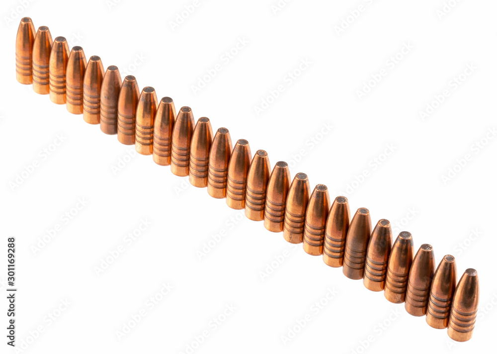 Expansive bullets with a copper shell and lead inside, 9 mm caliber, stand in a row, on a white background. Expansive bullets with a copper shell and lead inside, 9 mm caliber, stand in a row, on a white background.