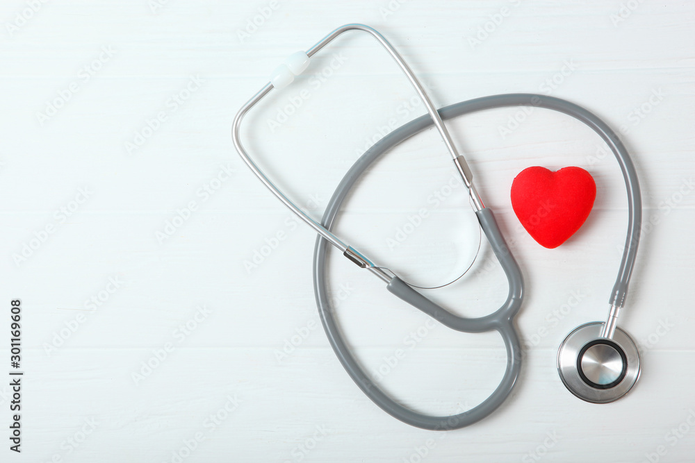 Stethoscope and heart on wooden color background. Health, medicine Stethoscope and heart on wooden color background. Health, medicine