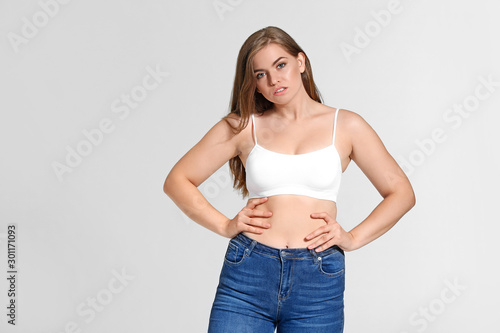 Young body positive woman on grey background