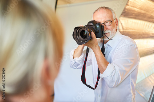 Senior photographer with camera takes portrait photos