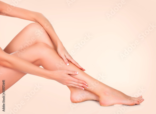 Woman sitting on the floor and touching her leg by hands, Beauty and skin care concept