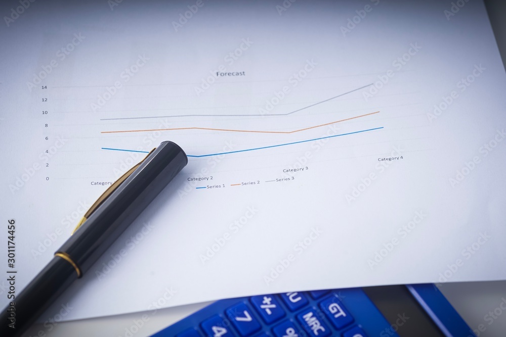Business and Finance concept: Graph on paper with pen and calculator on top of a desk. Business and Finance concept: Graph on paper with pen and calculator on top of a desk.