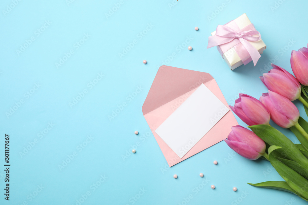 Flat lay composition with tulips and card on light blue background, space for text. Happy Mother's day - obrazy, fototapety, plakaty 
