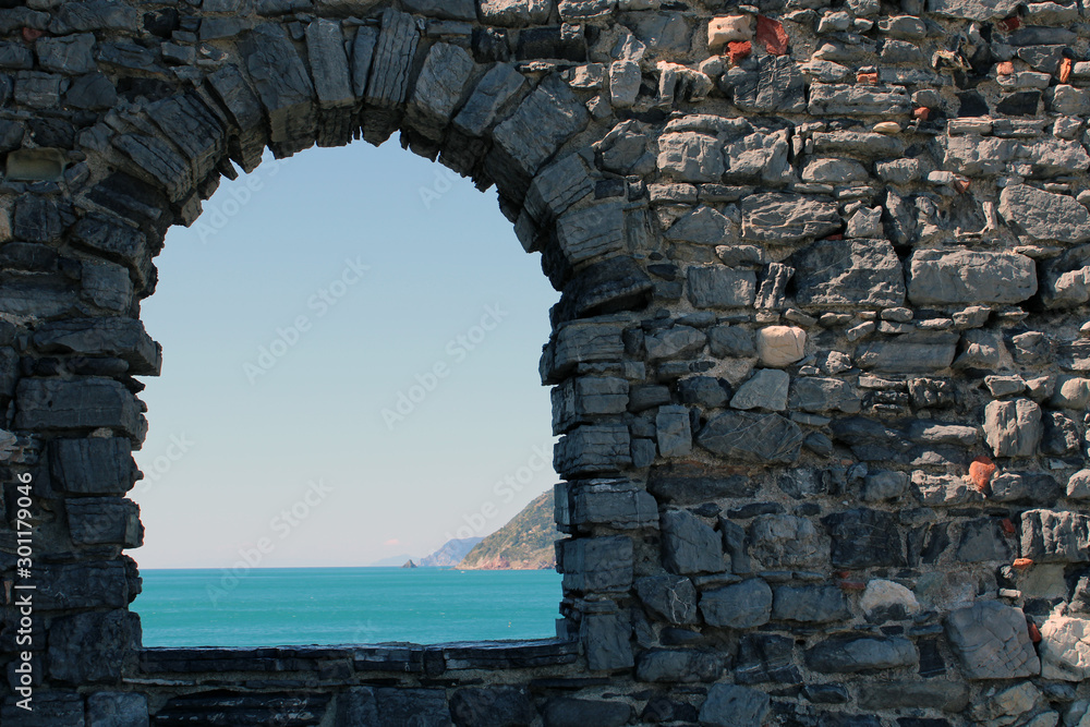 Arco e muro in pietra con vista mare