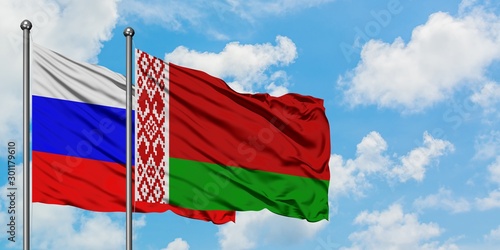 Russia and Belarus flag waving in the wind against white cloudy blue sky together. Diplomacy concept, international relations.