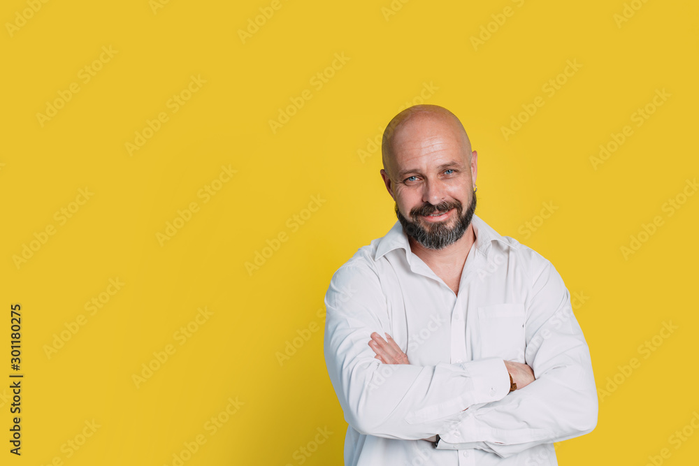 Handsome middle-aged man on yellow background looking at camera. with copy space Handsome middle-aged man on yellow background looking at camera. with copy space