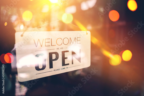 Open sign hanging front of cafe with colorful bokeh light abstract background.