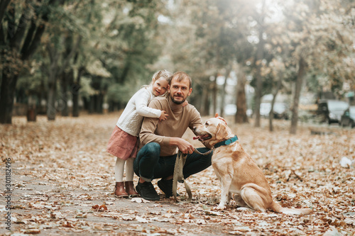 Father's day. Happy family daughter hugging dad and laughs outdoor in park. Father and daughter with their lovely dog playing in forest! Love relations family traditions concepts