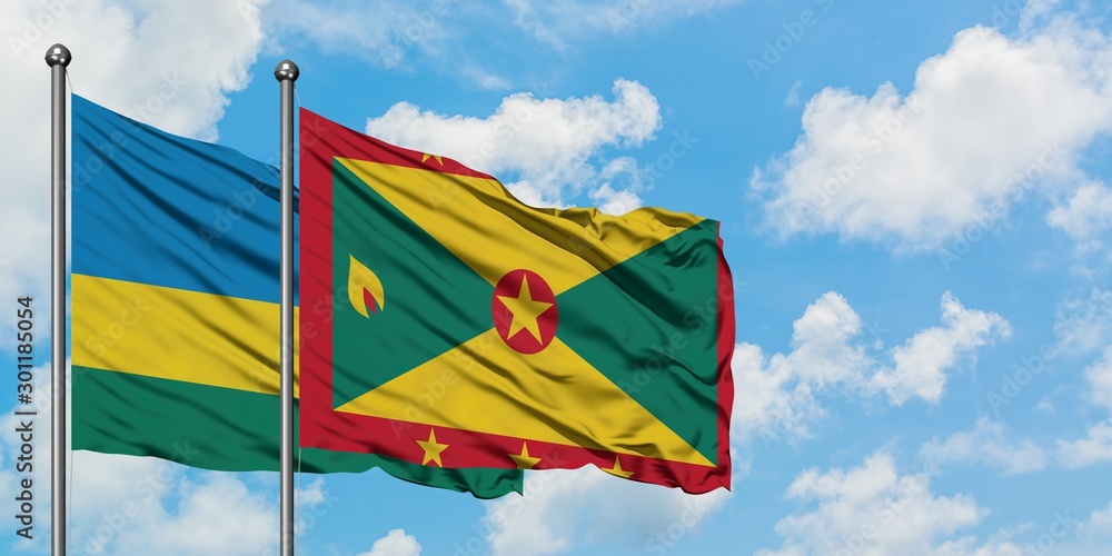 Rwanda and Grenada flag waving in the wind against white cloudy blue sky together. Diplomacy concept, international relations. Rwanda and Grenada flag waving in the wind against white cloudy blue sky together. Diplomacy concept, international relations.