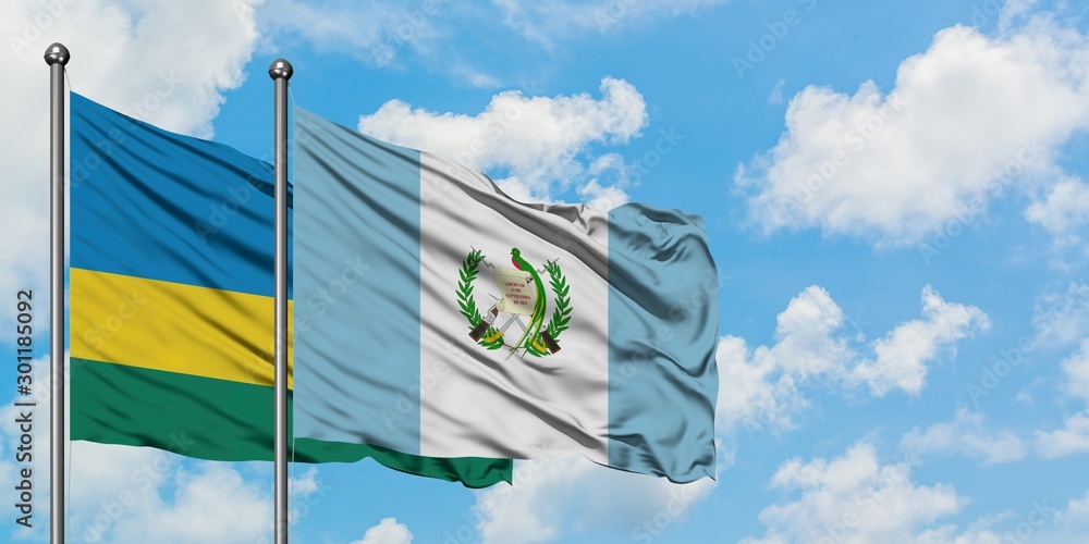 Rwanda and Guatemala flag waving in the wind against white cloudy blue sky together. Diplomacy concept, international relations. Rwanda and Guatemala flag waving in the wind against white cloudy blue sky together. Diplomacy concept, international relations.