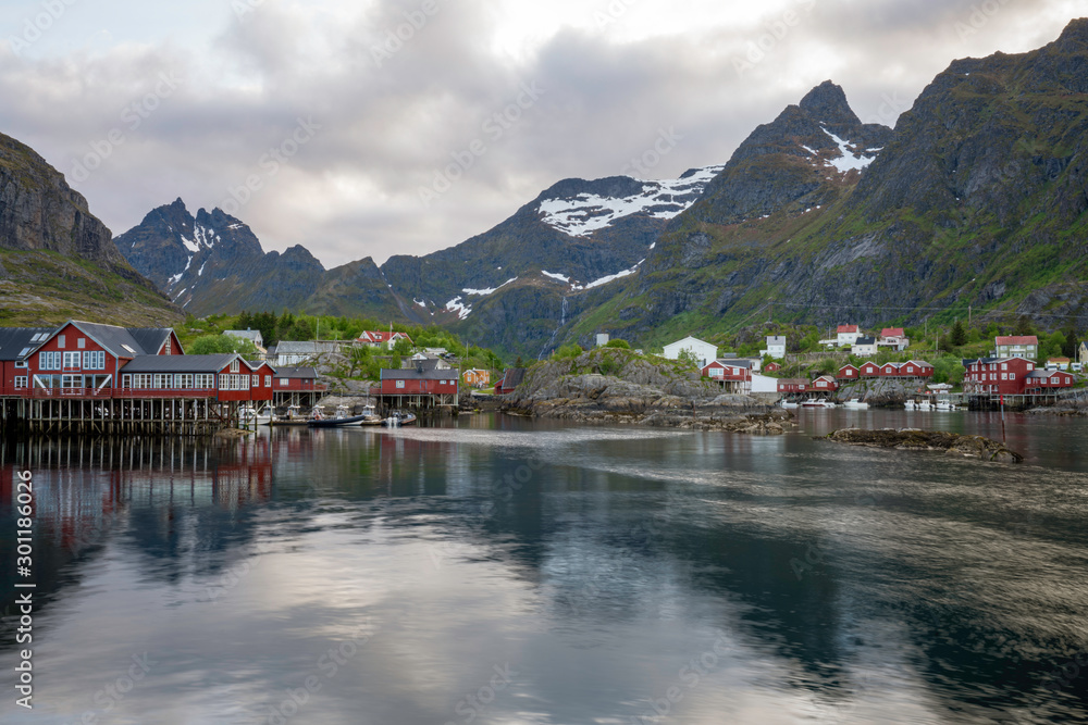A fishing village in Lofoten islands called A/Ã…. Red little houses and the beautiful mountain in the bckground with soft light. Travel and explore concept.