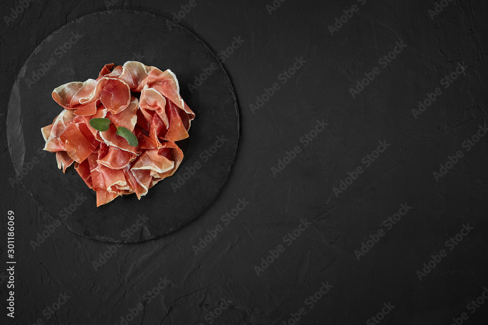 Gourmet, manually sliced jamon with herbs on black stone slate board  against a dark grey background. Close-up shot. Top view. Copy space. Stock  Photo | Adobe Stock