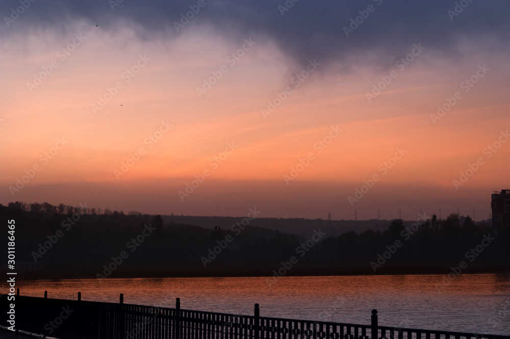 Obraz premium Unusual red sunset in a city park above the lake.