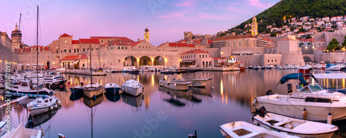 Panoramic view of Old Harbour with boats and Old Town of Dubrovnik at sunset, Croatia