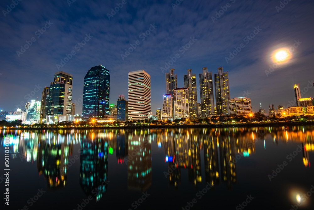 Fototapeta premium View of the Park in the night,Beautiful reflection of skyscrapers on Chao Phraya River Amazing night life in Bangkok city,Thailand.
