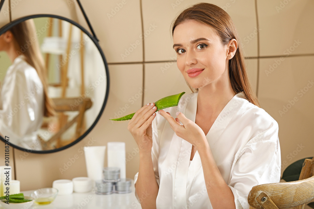 Beautiful young woman using aloe vera in bathroom Beautiful young woman using aloe vera in bathroom