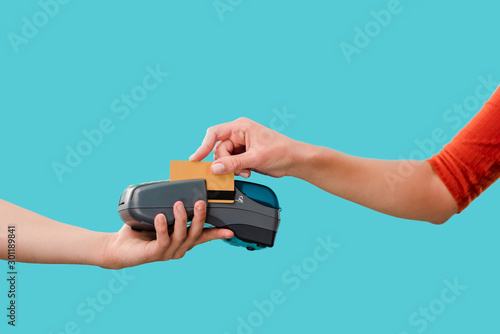 cropped view of woman paying with credit card on terminal, Isolated On blue photo