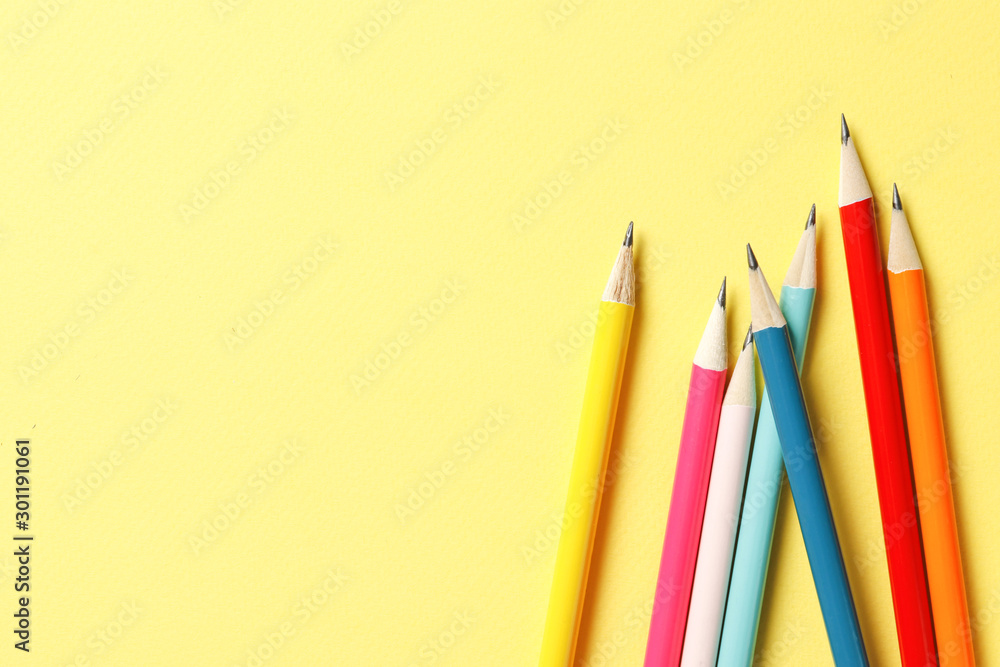 Fototapeta premium Color pencils on a yellow background. Place for text