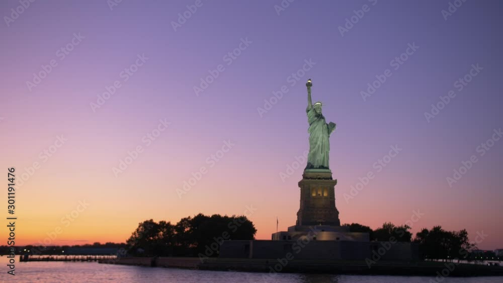 establishing shot of Statue of liberty silouhette at dawn, shot from a boat on teal and orange establishing shot of Statue of liberty silouhette at dawn, shot from a boat on teal and orange