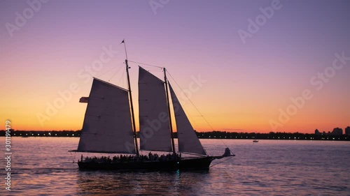 hudson river shot, from a boat, showing sailing ship, at dusk, teal and orange sky