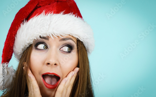Surprised woman in santa claus hat