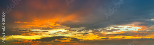 Panorama Sunlight with dramatic sky. Cumulus sunset clouds with sun setting down on dark background.Vivid orange cloud sky. © noon@photo