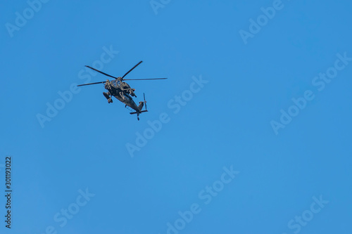 Military helicopter flying against a beautiful blue sky