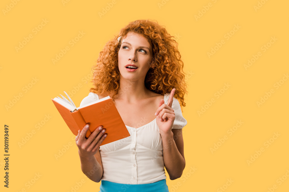 pensive redhead woman with book isolated on yellow pensive redhead woman with book isolated on yellow