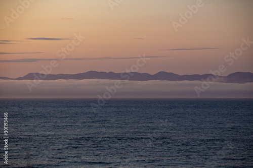 View of Vancouver Island from Port Angeles: the famous Washington State mist on the sea, with mountains in the background. Soft, romantic scenery.