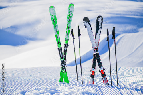 Obraz na plátně Skis in snow in winter season, mountains and ski items or equipments on the top