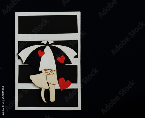 Homemade greeting card with contrasting stripes decorated with figure of lovers under umbrella, bright red hearts on black background. Symbolic concept of love, relationship, wedding. Minimal style.