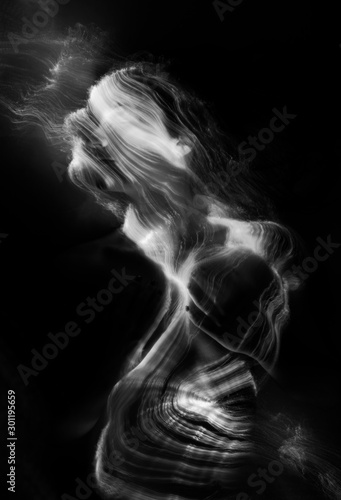 Fototapeta Naklejka Na Ścianę i Meble -  Conceptual monochrome black and white avant-garde portrait of a beautiful young girl covered with lines applied by a light brush. Art style creative photo. Advertising, fashion and commercial design.