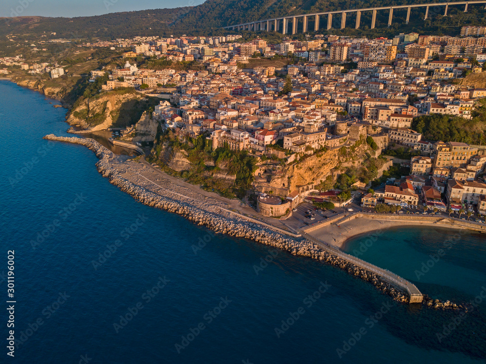 Fototapeta premium Aerial view of Pizzo Calabro, pier, castle, Calabria, tourism Italy. Panoramic view of the small town of Pizzo Calabro by the sea. Houses on the rock. On the cliff stands the Aragonese castle.