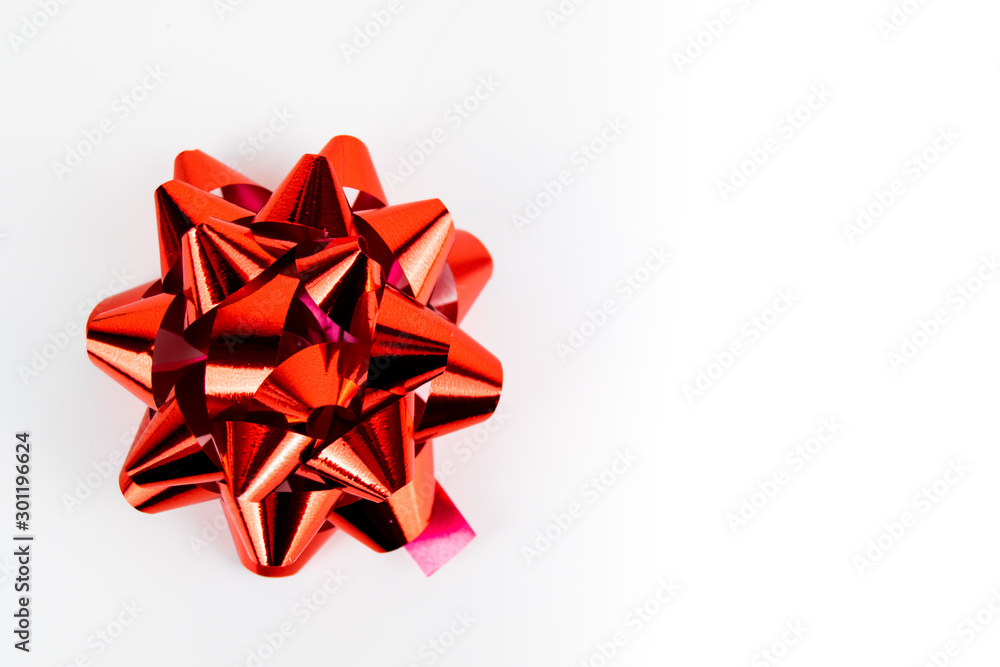 Red chrome foil effect Christmas present gift bow isolated against a white stark background Red chrome foil effect Christmas present gift bow isolated against a white stark background