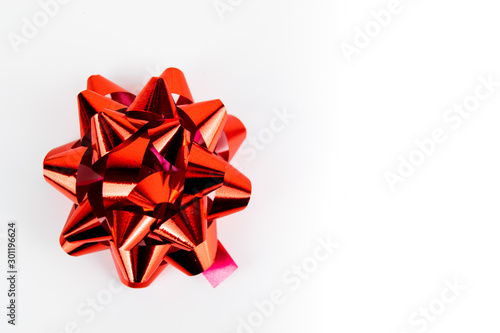 Red chrome foil effect Christmas present gift bow isolated against a white stark background