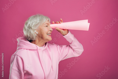 Φωτογραφία Positive cheerful old woman stand and look through rolled-up paper