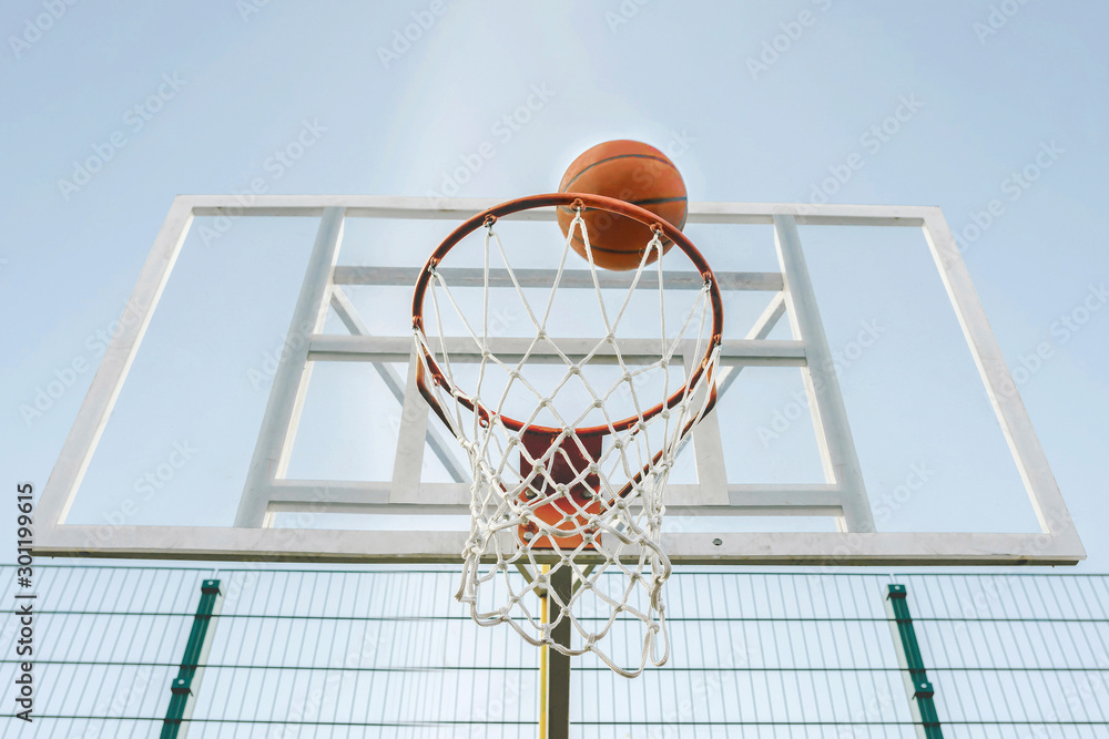 Basketball goes through the hoop on the sports field.