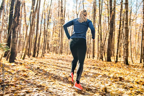 A Bautiful running woman jogging in autumn nature