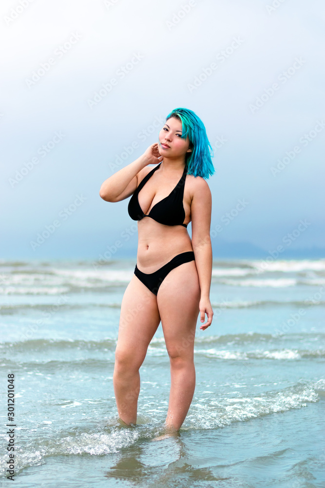 Blue hair girl, beach black bikini model full body shot, with ocean water  background foto de Stock | Adobe Stock
