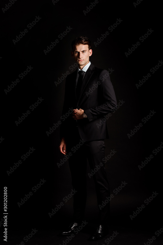 handsome businessman in suit standing isolated on black handsome businessman in suit standing isolated on black