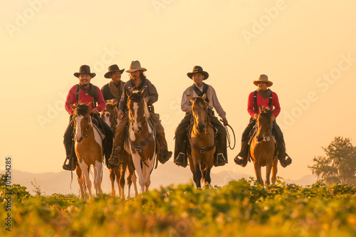 Group of Cowboy riding horse.Silhouette Cowboy on horseback.Cowboy  riding horse at sunset or sunrise time.  